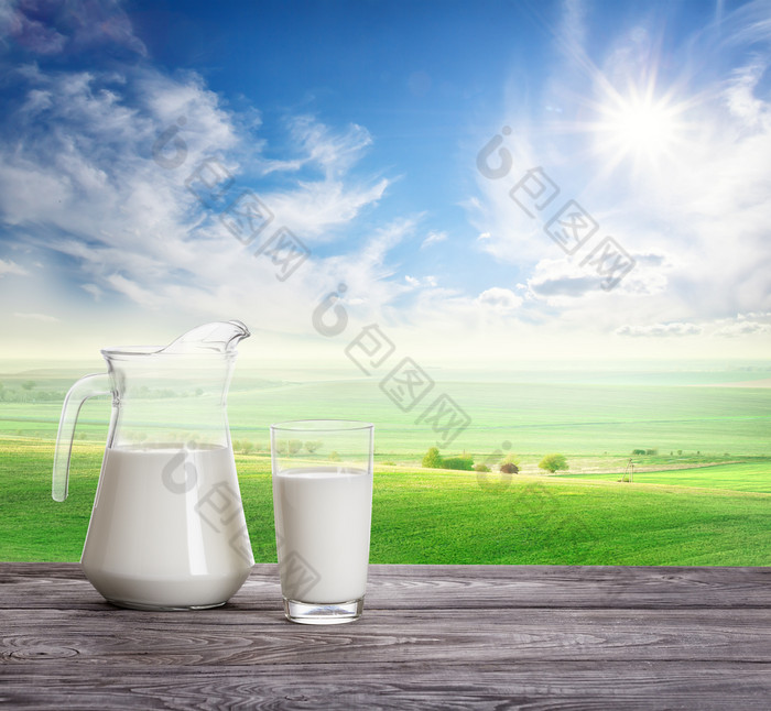 牛奶玻璃器皿对背景明亮的夏天景观的概念自然健康的食物牛奶玻璃器皿对背景明亮的夏天景观