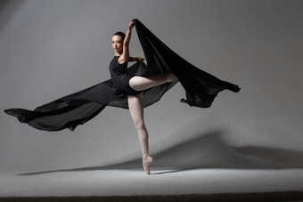 优雅的芭蕾舞女演员跳舞与黑色的布工作室摄影的概念美和格蕾丝优雅的芭蕾舞女演员跳舞与黑色的布