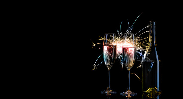 瓶和两个眼镜香槟五彩缤纷的孟加拉灯黑色的背景的概念庆祝活动新一年庆祝活动瓶和两个眼镜香槟五彩缤纷的孟加拉光