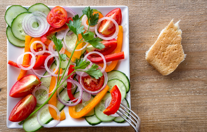 切片新鲜的蔬菜白色板与叉和面包视图从以上的概念橄榄自然食物切片新鲜的蔬菜白色板与叉