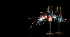 两个高眼镜香槟五彩缤纷的孟加拉灯黑色的背景轮廓的概念庆祝活动新一年庆祝活动两个高眼镜香槟五彩缤纷的孟加拉灯