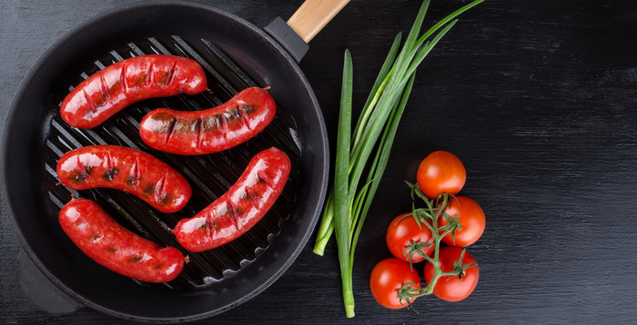 煎锅与炸香肠和西红柿与洋葱一边一边黑色的背景视图从以上复制空间煎锅与炸香肠和西红柿与洋葱