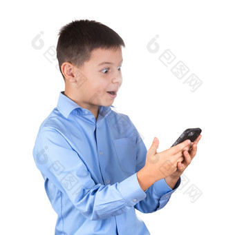 男孩蓝色的衬衫看起来的电话屏幕与令人惊讶的事物和高兴的是孤立的白色男孩蓝色的衬衫看起来的电话屏幕与令人惊讶的事物