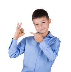 男孩的蓝色的衬衫持有的比特币和点与他的手指孤立的白色背景的概念比特币的货币的新一代和它的发展男孩的蓝色的衬衫持有的比特币和点