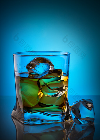 威士忌透明的玻璃与冰多维数据集说谎玻璃表格蓝色的背景威士忌透明的玻璃与冰多维数据集说谎玻璃表格