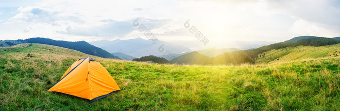 橙色帐篷草地与绿色草山下明亮的太阳多云的天空夏天景观全景橙色帐篷草地与绿色草山下明亮的