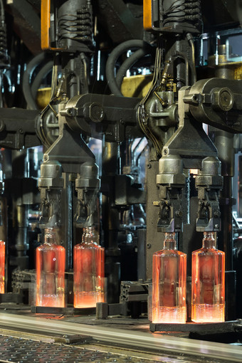 热滚肋瓶的输送机热红色的瓶移动沿着的输送机的玻璃工厂热滚肋瓶的输送机
