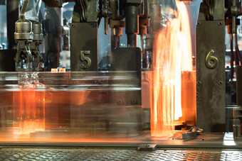 过程运动热玻璃瓶的输送机热红色的瓶移动沿着的输送机的玻璃工厂过程运动热玻璃瓶的输送机
