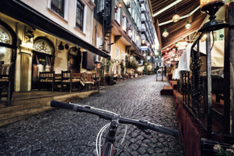 自行车操舵轮的背景明亮的城市街与点燃灯笼自行车操舵轮背景明亮的城市街