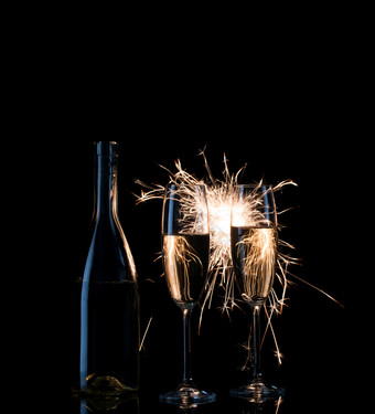 瓶和两个高眼镜香槟明亮的火花黑色的背景瓶和两个高眼镜香槟明亮的火花