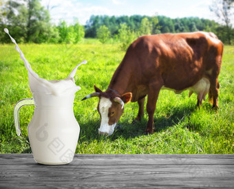 玻璃壶牛奶与飞溅的背景牛壶牛奶站木表格对的背景棕色（的）牛牧场玻璃壶牛奶与飞溅的背景牛
