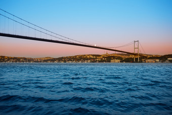桥在的<strong>横跨</strong>博斯普鲁斯海峡的《暮光之城》黎明下明亮的月亮伊斯坦布尔火鸡晚上景观桥在<strong>横跨</strong>博斯普鲁斯海峡《暮光之城》黎明下明亮的月亮