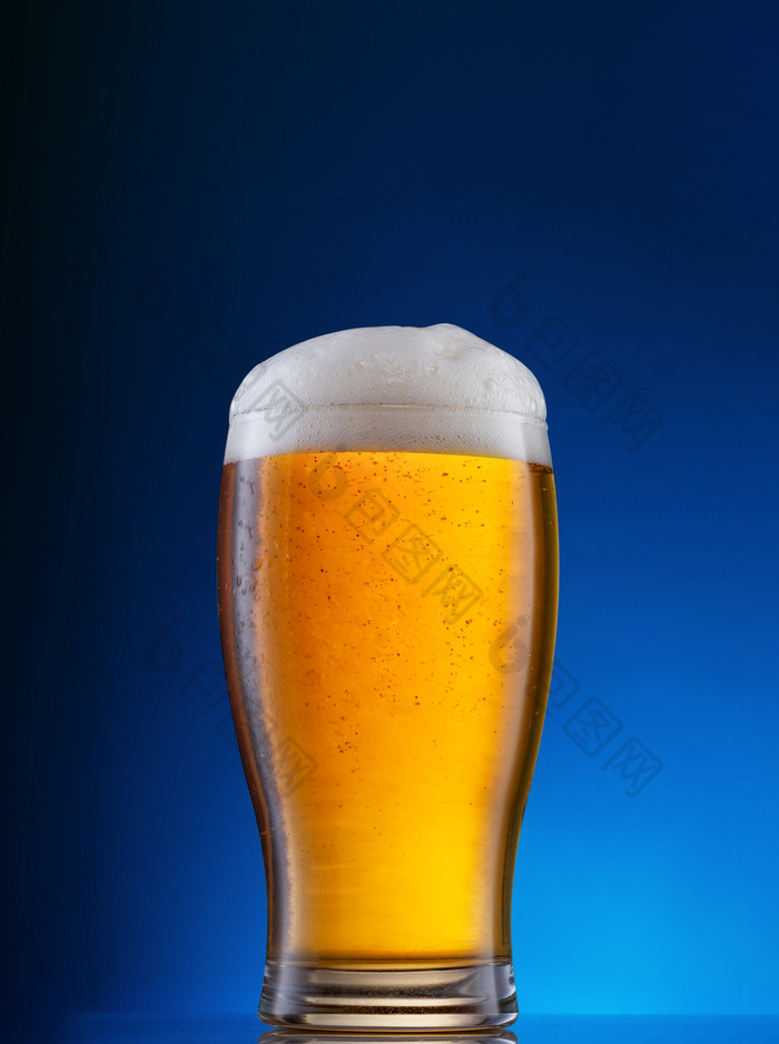 玻璃与光啤酒蓝色的背景玻璃与光啤酒蓝色的背景