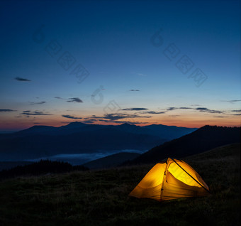 橙色点燃帐篷的<strong>山下</strong>的晚上天空夏天景观的概念自由孤独和旅行橙色点燃帐篷<strong>山下</strong>晚上天空