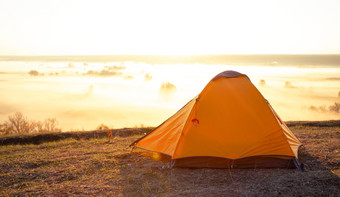 橙色旅游帐篷山以上的河覆盖与厚雾早期早....夏天景观的概念旅行自由和隐私橙色旅游帐篷山以上河覆盖与厚雾