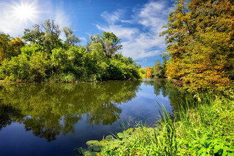 蓝色的河湖与绿色树的海岸的明亮的夏天太阳的概念生态清洁绿色地球自然旅行和孤独蓝色的河湖与绿色树的海岸