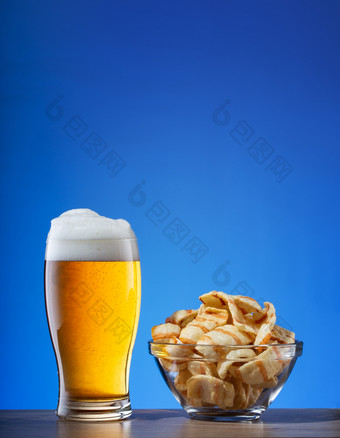 玻璃光啤酒和板芯片蓝色的背景玻璃光啤酒和板芯片蓝色的背景