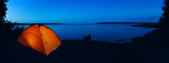 橙色<strong>点燃</strong>帐篷湖晚上天空全景的概念隐私旅行和和谐橙色<strong>点燃</strong>帐篷湖