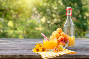 杏汁与杏子和黄色的花木表格网纹黄色的餐巾绿色自然背景杏汁与杏子和黄色的花木表格