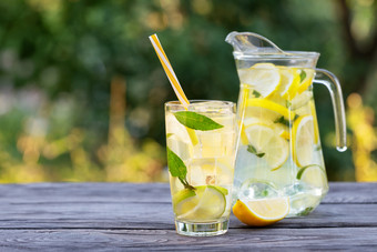 柠檬<strong>水壶</strong>和玻璃和片柠檬木表格自然绿色背景夏天让人耳目一新喝柠檬<strong>水壶</strong>和玻璃和片柠檬木表格