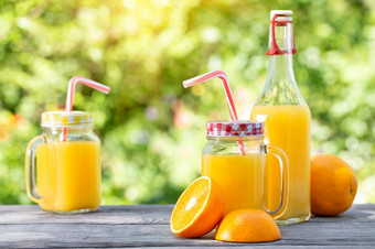 橙色汁和<strong>切片</strong>橙子木表格自然绿色背景橙色汁和<strong>切片</strong>橙子木表格