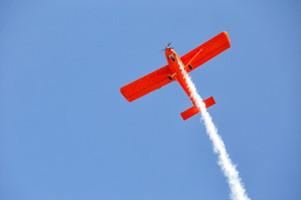 红色的飞机<strong>发出</strong>烟的蓝色的天空空气显示红色的飞机<strong>发出</strong>烟蓝色的天空