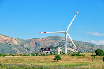 风涡轮和房子<strong>山下</strong>蓝色的天空元素风权力站替代能源概念火鸡风涡轮和房子<strong>山下</strong>蓝色的天空
