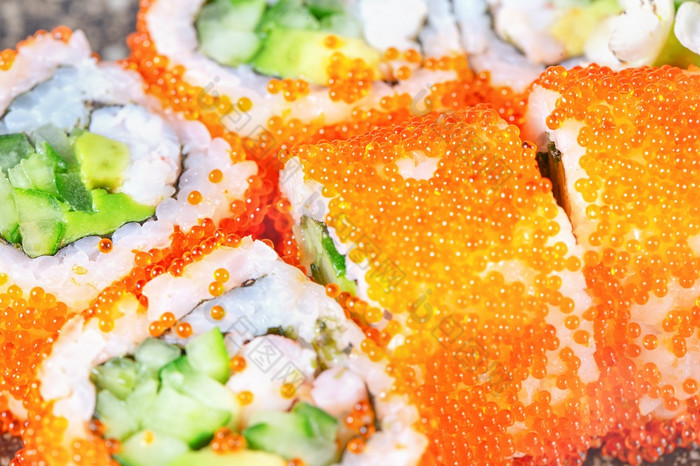 一块寿司卷与红色的鱼子酱和鳄梨一块寿司卷与红色的鱼子酱和鳄梨