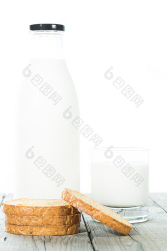 瓶新鲜的牛奶与烤面包而且与白色背景