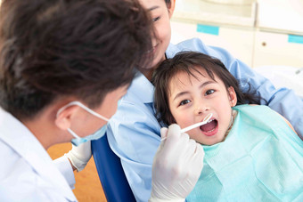 牙科医生给小女孩检查牙齿