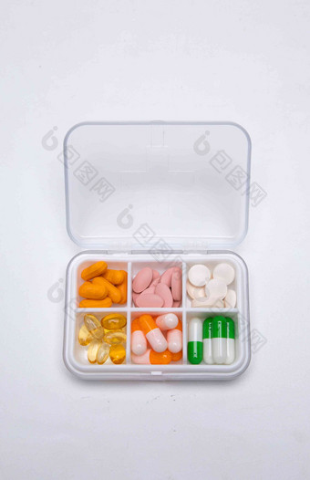 装满多色药丸的药盒白色背景写实摄影图