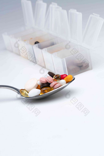 匙上的多色药丸和药盒夸张清晰相片