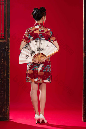 穿旗袍的青年女人拿着折扇站着高质量图片
