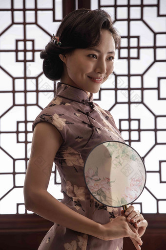 穿旗袍拿着扇子的东方女人中国文化照片