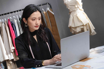 服装设计师使用笔记本电脑青年女人清晰摄影图