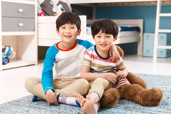 两个男孩坐在卧室的地毯上生长高端场景