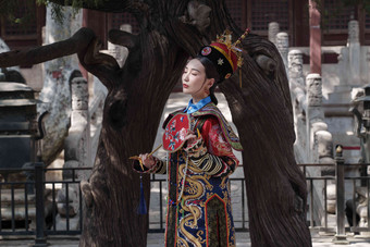 穿清宫服的青年女人站在古树下古典风格写实相片