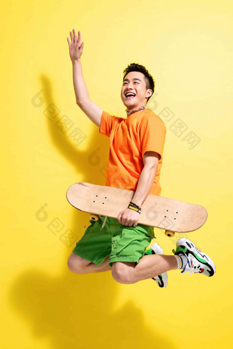 拿着滑板跳跃的青年男人滑板运动高质量相片