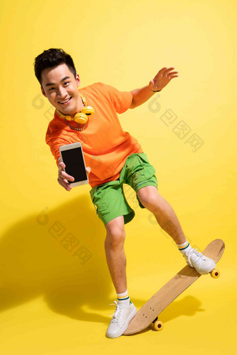 拿着手机玩滑板的青年男人手机高质量场景