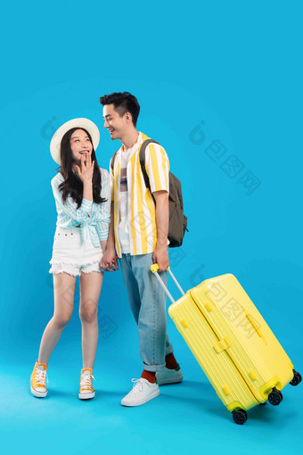 快乐的青年情侣拉着行李箱去旅游