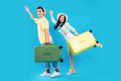 快乐的青年情侣一起拎着行李箱去旅游