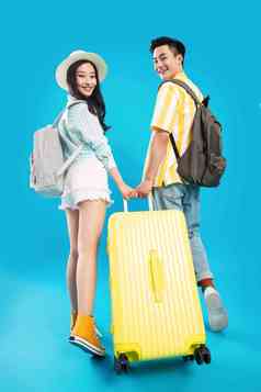 快乐的青年情侣一起拉着行李箱去旅游