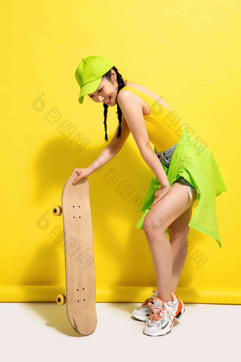 扶着滑板的年轻女孩快乐高清场景