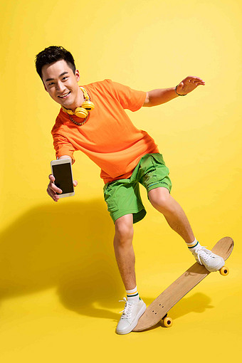 拿着手机玩滑板的青年男人享乐高端图片