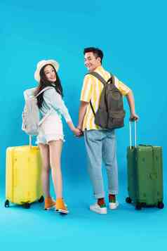 快乐的青年情侣推着行李箱去旅游