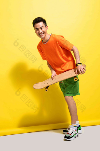拿着滑板的快乐青年男人滑板运动清晰摄影图