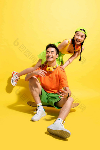 快乐的青年伴侣一起玩滑板坐着氛围摄影图