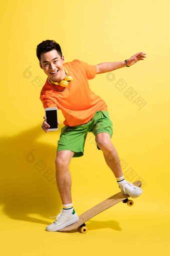 拿着手机玩滑板的青年男人滑板运动清晰镜头
