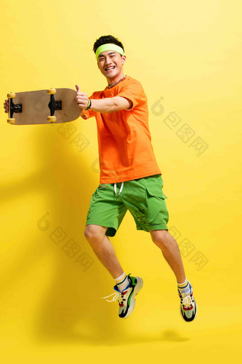 举着滑板跳跃的活力青年男人项链高质量相片