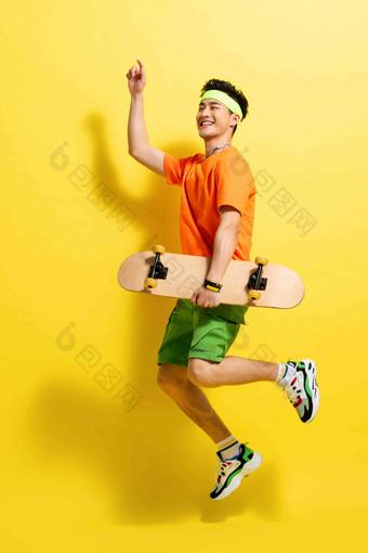 拿着滑板跳跃的活力青年男人健康的清晰摄影